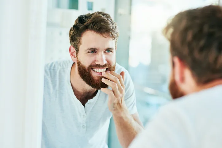 Man inspecting his smile in the mirror