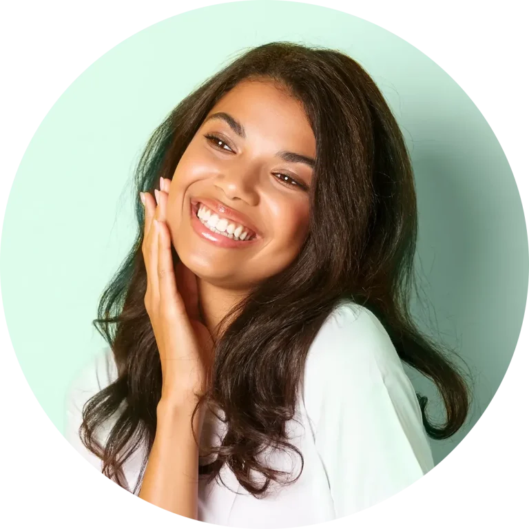 Woman smiling next to a green wall